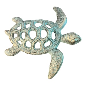 May include: A cast metal turtle figurine with a distressed, aged appearance. The turtle has a turquoise and bronze color scheme, with a hollow, honeycomb-patterned shell. The figurine is approximately 6 inches long.