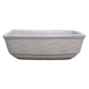 May include: A rectangular, off-white ceramic dish with a wavy design on the sides. The dish has a slightly raised rim and a smooth, glossy finish. This decorative dish is suitable for serving food or as a decorative accent.