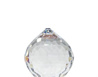 May include: A clear crystal ball with a faceted surface. The ball is round and has a smooth, polished finish.