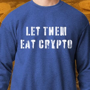 以下が含まれることがあります： ロイヤルブルーのトレーナーに「LET THEM EAT CRYPTO」という白い文字がプリントされています。