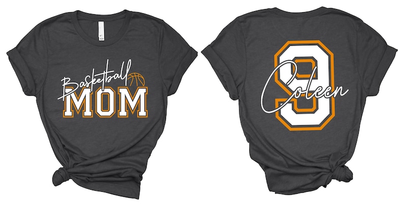 May include: Dark gray t-shirt with "Basketball MOM" in white and gold lettering, a basketball graphic, and the name "Coleen" and the number 9 on the back. The shirt has a crew neck and short sleeves.