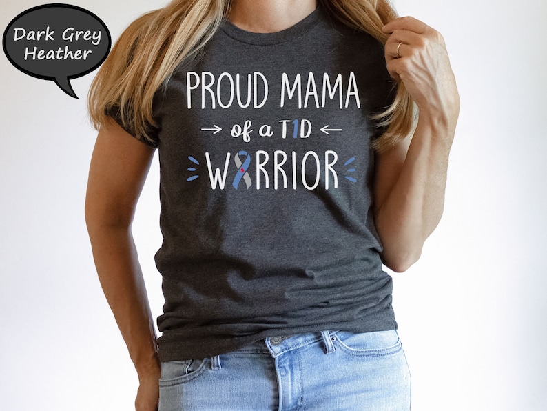 May include: Dark grey heather t-shirt with the text "Proud Mama of a T1D Warrior" in white with a blue ribbon graphic.