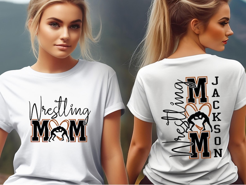 以下が含まれることがあります： 黒いスクリプトとブロック文字で「Wrestling MOM」とレスリングのグラフィックが描かれた白いTシャツ。シャツの背面には、同様のデザインで「Wrestling MOM Jackson」と表示されています。