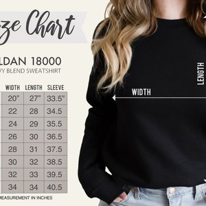 Puede incluir: Una sudadera negra Gildan 18000 de mezcla pesada con una tabla de tallas. La tabla muestra medidas en pulgadas para el ancho, largo y largo de la manga, que van desde la talla S hasta la 5XL. La imagen tambi&eacute;n muestra el ancho y el largo de la sudadera.