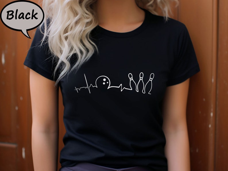 Puede incluir: Camiseta negra con un gr&aacute;fico blanco de una bola de bolos y bolos con una l&iacute;nea de latido del coraz&oacute;n.