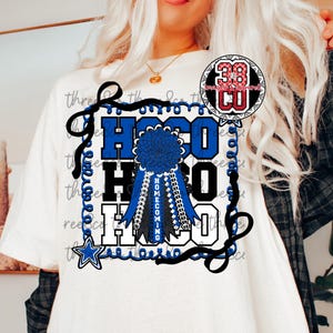 Könnte beinhalten: Weißes T-Shirt mit einem blau-schwarzen Homecoming-Design. Das Design zeigt die Buchstaben "HOCO" in Blau und Schwarz, eine blaue Rosette und einen Stern. Das T-Shirt hat einen Rundhalsausschnitt.