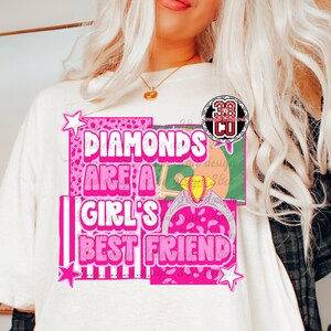 May include: Cream-colored t-shirt with the text "Diamonds Are A Girl's Best Friend" in pink, featuring a diamond ring graphic. The design includes pink stars and a leopard print pattern.
