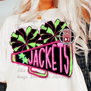 May include: White t-shirt featuring a megaphone design with the word "JACKETS" in pink and black. The megaphone is outlined in neon green and pink, with green and black pom-poms and a blue star. A logo is also visible.