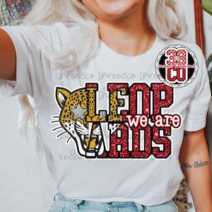 May include: White t-shirt with a leopard graphic and the text "LEOPARDS we are". The leopard has a yellow and brown spotted pattern with a star. The text is in red glitter and black.