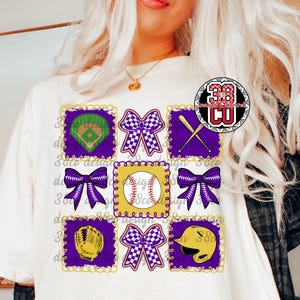 Puede incluir: Camiseta blanca con un diseño de béisbol. El diseño incluye un campo de béisbol, una pelota de béisbol, un guante, un casco, bates cruzados y lazos en morado, amarillo y blanco. También es visible el texto "38co design".