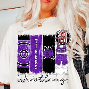 Può includere: T-shirt bianca con un design di wrestling viola e nero. Il design include la parola "Tigers", un grafico del tappeto di wrestling, un grafico del copricapo di wrestling e un grafico dell'uniforme di wrestling. La parola "Wrestling" è scritta in corsivo.