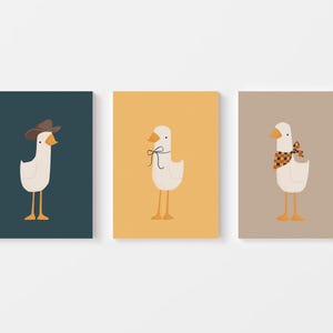 May include: Three illustrations of white geese with different accessories. The first goose is wearing a brown cowboy hat. The second goose is wearing a black bow. The third goose is wearing a red and black checkered bandana.