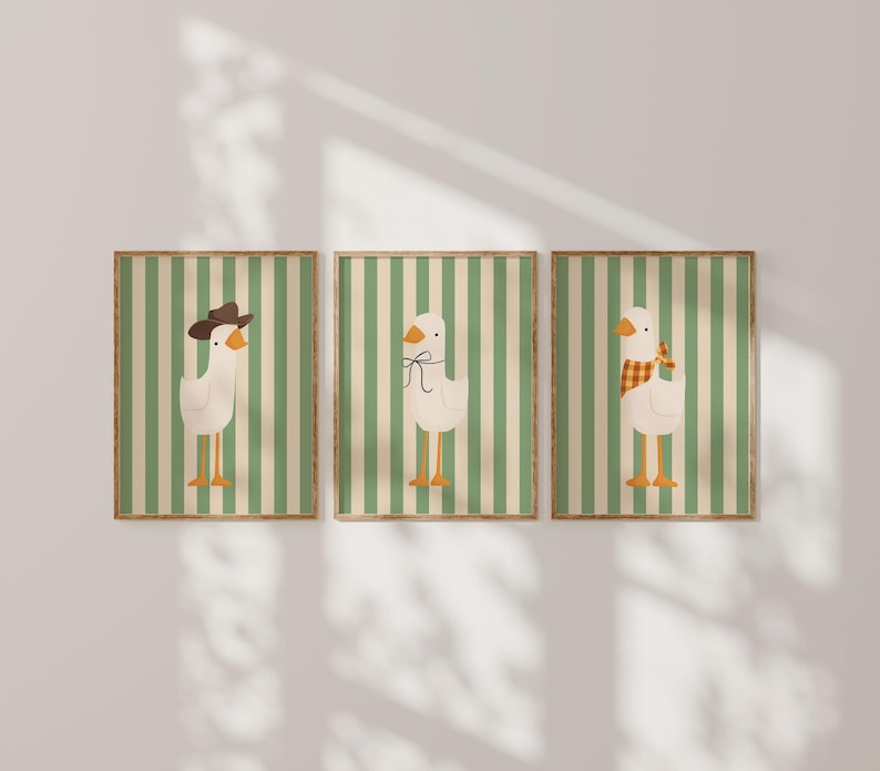 May include: Three framed prints with a green and white striped background. Each print features a white goose with different accessories. The first goose is wearing a brown cowboy hat, the second goose is wearing a brown bow tie, and the third goose is wearing a plaid scarf.