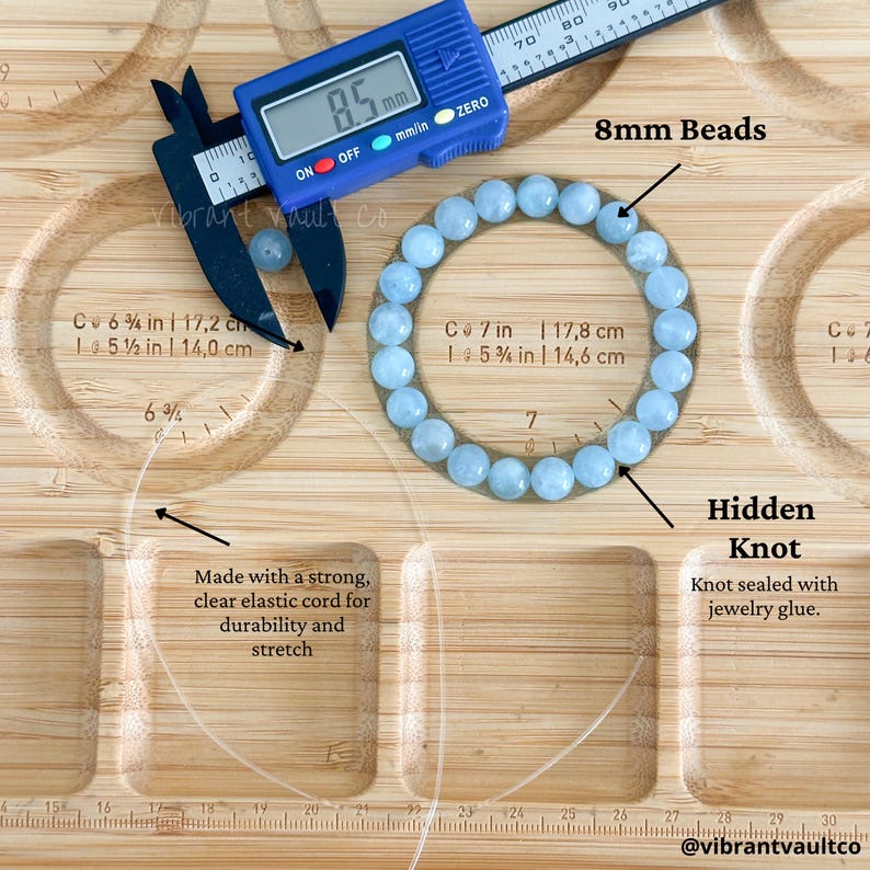 K&ouml;nnte beinhalten: Ein hellblaues Perlenarmband mit 8 mm Perlen. Das Armband wird mit einem digitalen Messschieber mit 8,5 mm gemessen. Der Text lautet: "Hergestellt mit einer starken, transparenten elastischen Schnur f&uuml;r Haltbarkeit und Dehnung."