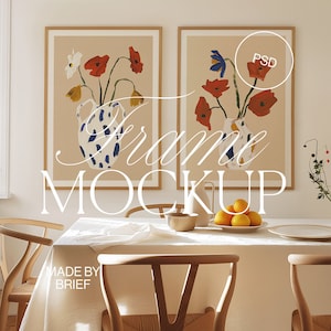 May include: Two framed illustrations of floral arrangements in vases. The illustrations are in a modern style with bold colours and simple lines. The frames are a light wood colour and are hanging on a white wall. The text "PSD" is visible in the top right corner of the right frame.