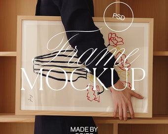 May include: A rectangular wooden frame mockup with a floral art print. The artwork features a vase with black and white stripes, red and yellow flowers, and the text "Frame Mockup". The image also includes the text "Made by Brief" and "PSD".