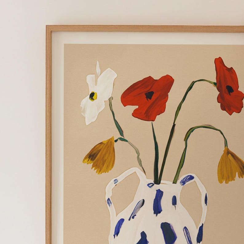 K&ouml;nnte beinhalten: Eine wei&szlig;e Vase mit einem abstrakten Muster in Blau und Wei&szlig;, gef&uuml;llt mit roten und wei&szlig;en Blumen. Die Blumen sind in einem Strau&szlig; mit gr&uuml;nen Stielen angeordnet.