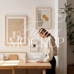 Könnte beinhalten: Ein Mockup eines gerahmten Kunstwerks mit einer Frau, die daneben steht. Das Kunstwerk ist ein minimalistisches abstraktes Design mit einem hellbraunen Hintergrund und einigen gelben Kreisen. Der Rahmen ist ein einfacher Holzrahmen. Die Frau trägt ein weißes Hemd und eine schwarze Hose. Der Text "Frame Mockup" ist über das Bild gelegt. Der Text "Made by Brief" ist ebenfalls auf dem Bild zu sehen.