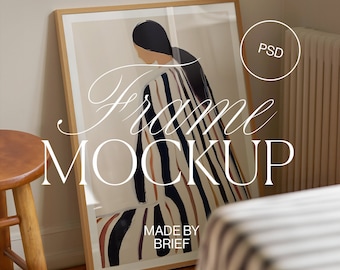 May include: A framed print of a colorful abstract painting of a person in a striped dress. The frame is made of wood and has a white mat. The print is leaning against a wall and a wooden stool is in the foreground. The text "Frame Mockup" and "Made by Brief" is visible on the print.