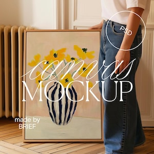 May include: A framed canvas mockup featuring a painting of yellow flowers in a black and white striped vase on a light pink background. The text "canvas mockup" is superimposed on the image. The text "made by BRIEF" is at the bottom of the canvas.