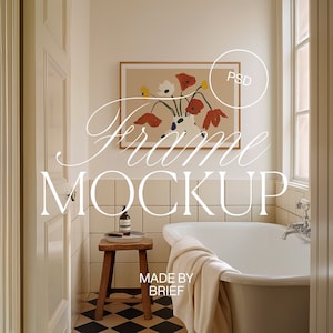 May include: A white bathroom with a bathtub, a wooden stool, and a framed painting of flowers. The painting is in a wooden frame and has a light brown background with red, yellow, and white flowers. The text "Frame Mockup" is written in white on the image. The text "Made by Brief" is written in white on the bottom of the image.