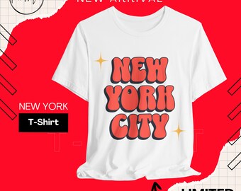 May include: White t-shirt with a red "NEW YORK CITY" graphic in a retro font style. The text is outlined in black and has a sparkle effect on either side. The shirt is a new arrival and part of a limited collection.