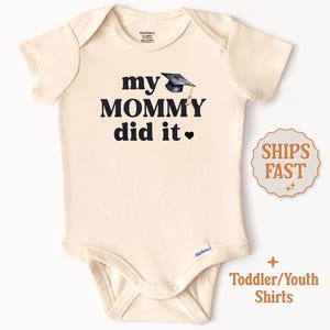 May include: A cream-colored toddler/youth bodysuit with black text that reads "my mommy did it" and a small black graduation cap graphic.