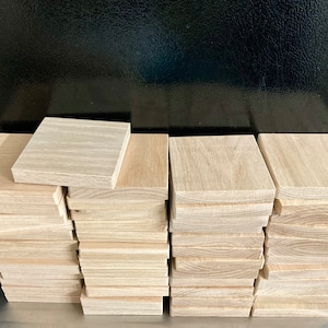Może przedstawiać: Stos 10 drewnianych kwadrat&oacute;w, każdy o wymiarach około 10 cm x 10 cm. Kwadraty są wykonane z jasnego drewna o naturalnym usłojeniu.