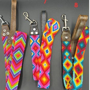 May include: A collection of colorful woven straps with leather accents and metal clasps. The straps feature vibrant geometric patterns in shades of pink, orange, yellow, green, and blue. The leather is brown and the clasps are silver.