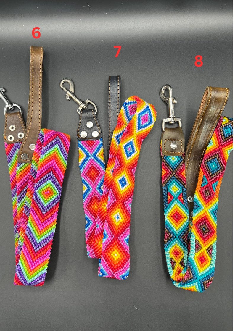 May include: A collection of colorful woven straps with leather accents and metal clasps. The straps feature vibrant geometric patterns in shades of pink, orange, yellow, green, and blue. The leather is brown and the clasps are silver.