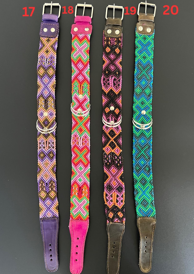 May include: Four colorful dog collars with intricate woven patterns. Each collar features a different color scheme: purple, pink, black, and blue. They have silver metal hardware and leather ends. The collars are designed for pets.