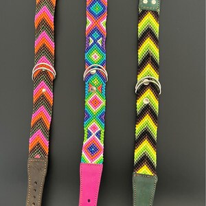 May include: Three colorful dog collars with intricate beaded patterns. The collars feature brown, pink, and green leather accents, silver metal hardware, and vibrant geometric designs in shades of orange, pink, blue, green, and yellow.