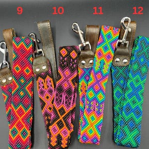 May include: A collection of colorful woven straps with leather accents and metal clasps. The straps feature geometric patterns in various colors, including red, orange, pink, purple, green, and blue. Each strap is labeled with a number from 9 to 12.