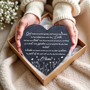 May include: A heart-shaped black slate stone with white floral and butterfly accents, and the word "Home". The stone has an inscription with a poem. The stone is presented in a brown gift box.