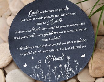 May include: A round, dark gray memorial stone with white text. The inscription includes the words "God," "Earth," and "Home," along with a poem about loss. Delicate floral and butterfly designs are also present.