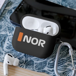 May include: Black AirPods Pro case with the word "NOR" in white and an orange vertical stripe. The case is open, revealing white AirPods inside. A silver carabiner clip is attached to the case.