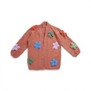 May include: A rust-colored cardigan with a long sleeve and open front. The cardigan is decorated with colorful crocheted flowers.