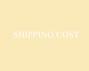Op de afbeelding: Een witte tekstafbeelding op een lichtgele achtergrond met de tekst "SHIPPING COST".