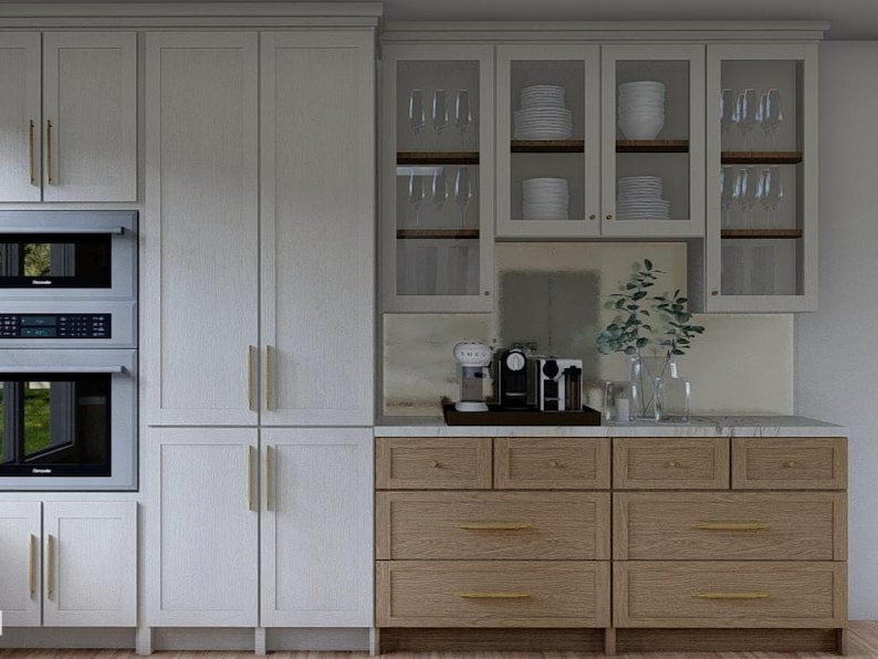 May include: A modern kitchen design featuring white cabinetry with gold hardware, a built-in microwave and oven, and a light wood base cabinet. Glass-fronted upper cabinets display dishware and glassware. A coffee station sits on the countertop.