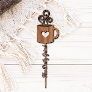 Op de afbeelding: Een witte keramische mok met een zwart handvat en de tekst "But First, Coffee" in een zwarte, handgeschreven lettertype. De mok staat op een wit oppervlak.