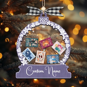 May include: A purple Christmas ornament shaped like a snow globe, with miniature book covers inside. It has a black and white checked bow and the year "2025". The bottom of the ornament says "Custom Name".
