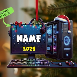 May include: A Christmas ornament featuring a computer setup with a monitor, keyboard, mouse, and PC tower. The monitor displays the name "NAME" and the year "2024". A Santa hat rests on the PC tower. The ornament is flat.