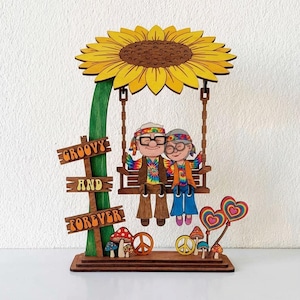 May include: Wooden decorative piece featuring a sunflower with a swing holding two elderly cartoon characters. The sign reads "Groovy and Forever". Additional elements include mushrooms, peace signs, and heart-shaped lollipops.