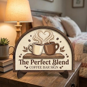 Może przedstawiać: Drewniany szyld do baru kawowego z półokrągłym blatem. Znak przedstawia dwa kubki kawy z parą tworzącą kształt serca, ziarna kawy i napis "The Perfect Blend COFFEE BAR SIGN."
