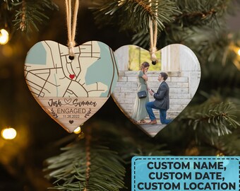 May include: A heart-shaped wooden ornament with a map on one side and a photo on the other. The map side shows a location with the text "Josh & Summer Engaged 11.26.2022". The photo side shows a couple getting engaged.