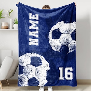 May include: Blue fleece blanket with a white soccer ball design and the text "NAME" and "16".