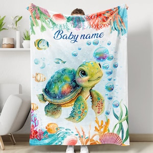 May include: A personalized baby blanket with a colorful cartoon sea turtle surrounded by bubbles and coral. The blanket has the text "Baby name" on it.