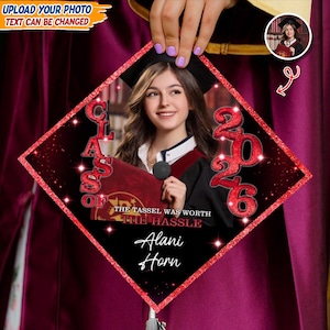 Op de afbeelding: Een afstudeerhoed met een foto van een lachende persoon, de tekst "Class of 2026" en de woorden "The Tassel Was Worth The Hassle" in rood en wit. De hoed heeft een rode glitterrand en de naam "Alani Horn".