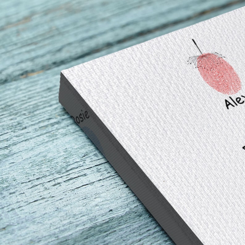 May include: A white canvas print with two pink fingerprints and the names "Alex" and "Rosie" written in black ink.