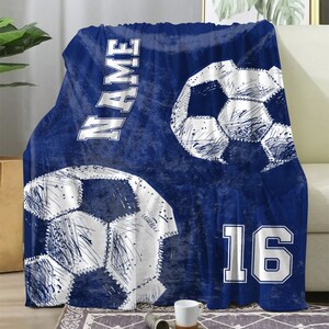 May include: Blue fleece blanket with a white soccer ball design and the number 16. The blanket also has the word "NAME" written on it.